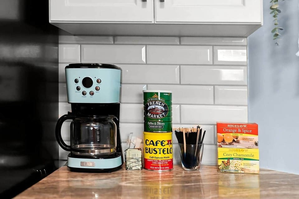 A dedicated coffee station stocked with regular and decaf coffee, a variety of teas, and sugar. Start your day with a fresh brew using the drip coffee maker, all set in a cozy and convenient spot for your morning routine.