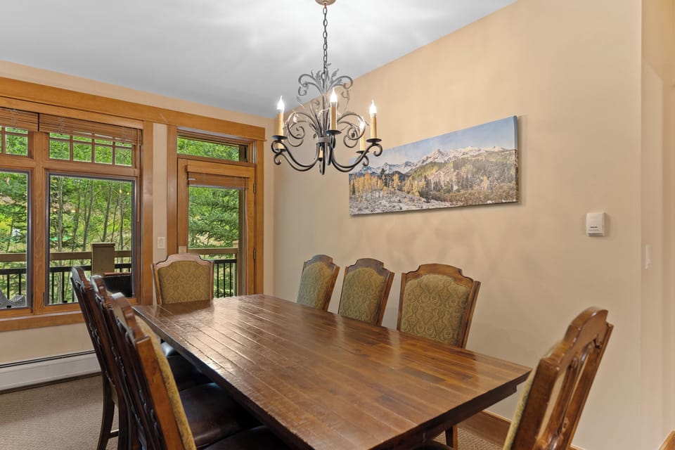 Gather your group around this elegant dining table, where the chandelier creates perfect ambiance for memorable meals together.