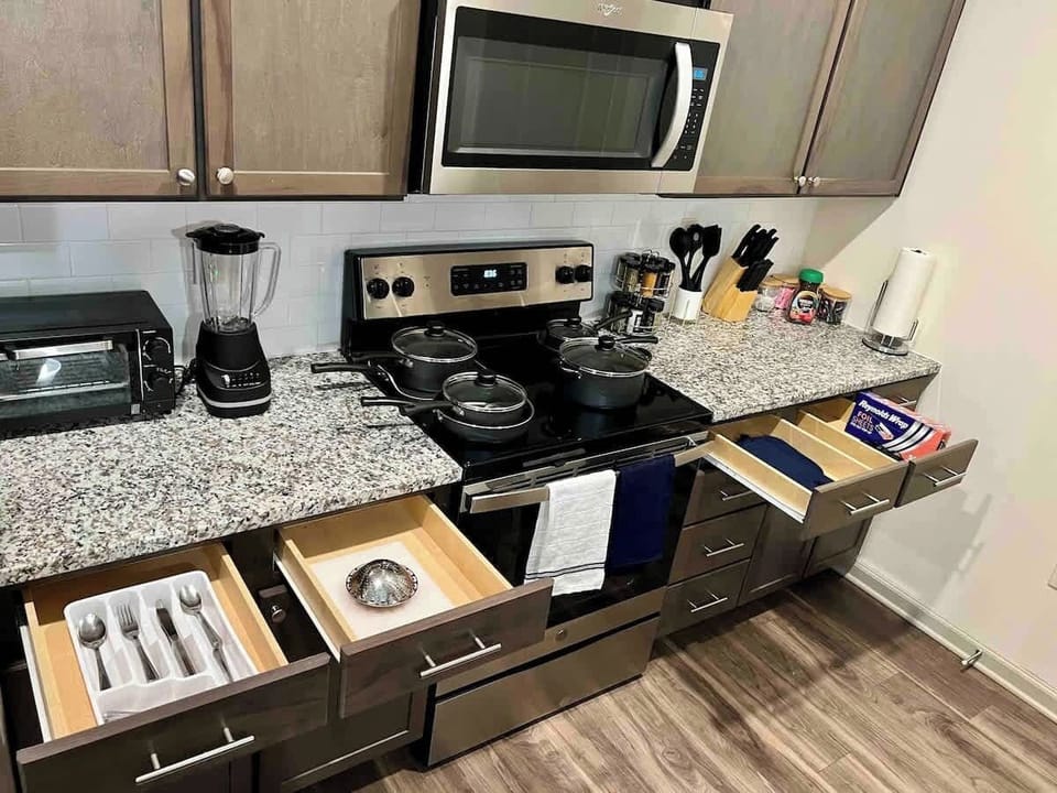 Experience culinary delight in our modern kitchen, equipped with a gas stove, oven, microwave, and elegant cabinetry. A perfect space for creating delicious meals and making lasting memories.