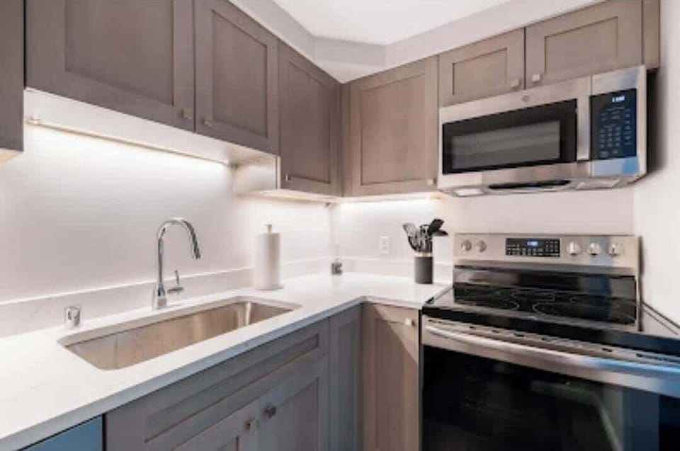 Sink, stove and microwave in kitchen.