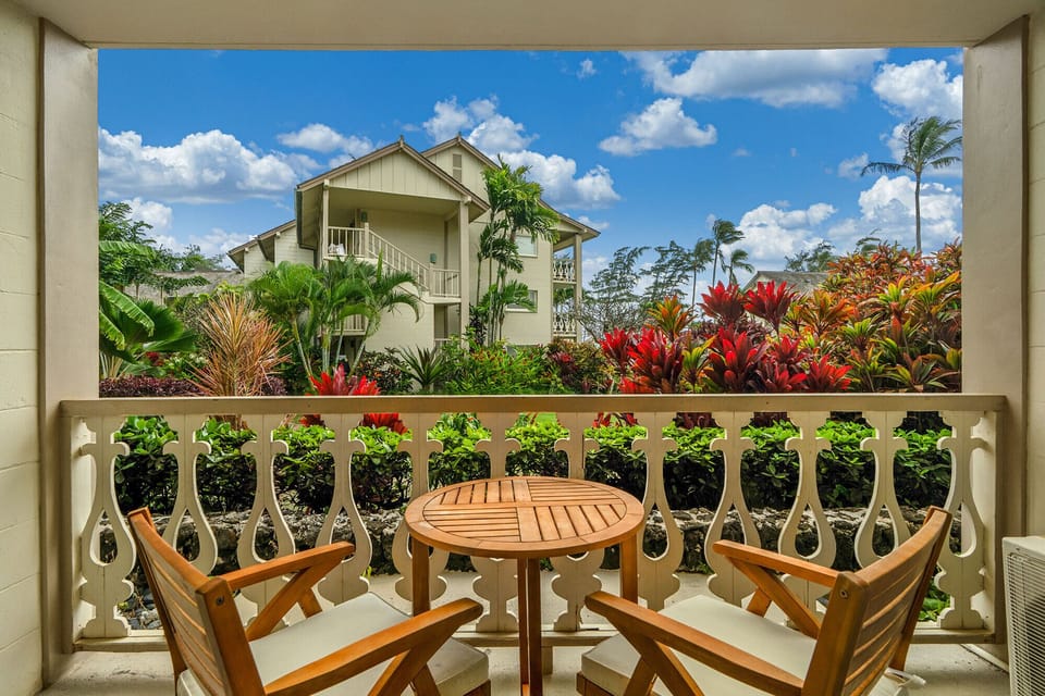 Your private balcony overlooks tropical gardens with vibrant red foliage, creating a serene spot to enjoy morning coffee or evening relaxation.