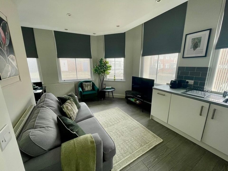 A relaxing open-plan living space with a Smart TV offering Netflix and a comfortable sofa bed. The layout includes a small dining nook and a combined kitchen and lounge area, creating a practical and inviting place to unwind.
