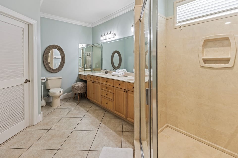 Your spacious bathroom features warm wood vanity, elegant mirrors, and a refreshing shower where you'll start each day feeling rejuvenated.