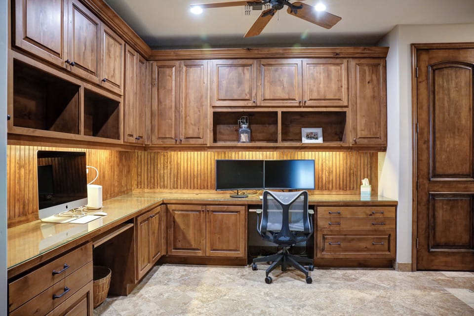 Office area with monitors and comfy office chair is just off the kitchen.