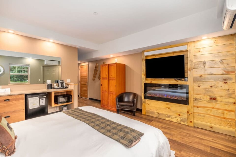The room has a big smart TV and electric fireplace