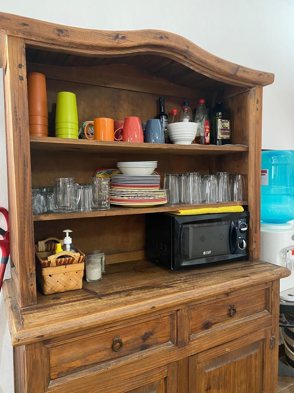 Kitchen dishware: mugs, cups, glasses, cutlery, bowls, plates & microwave.