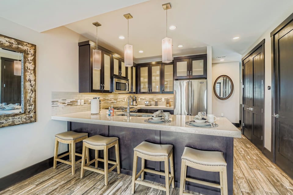 Whip up local delicacies in this sleek, modern kitchen at Blackstone. Enjoy stainless steel appliances, elegant pendant lighting, and a spacious breakfast bar perfect for quick morning bites.