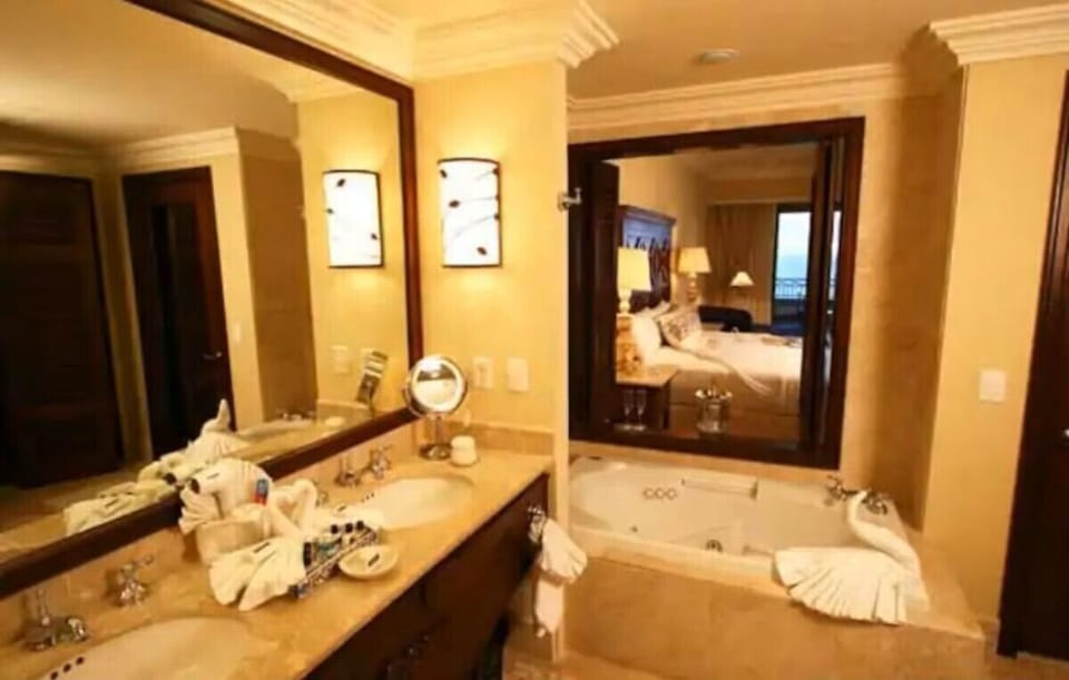 Primary bathroom with view to bedroom and balcony