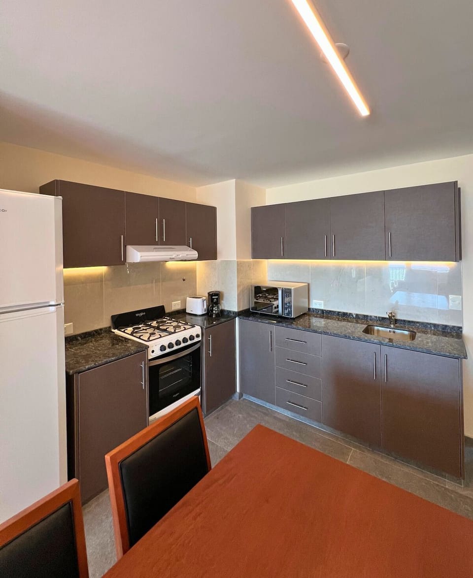 Cook with ease in a full kitchen beside dining table.