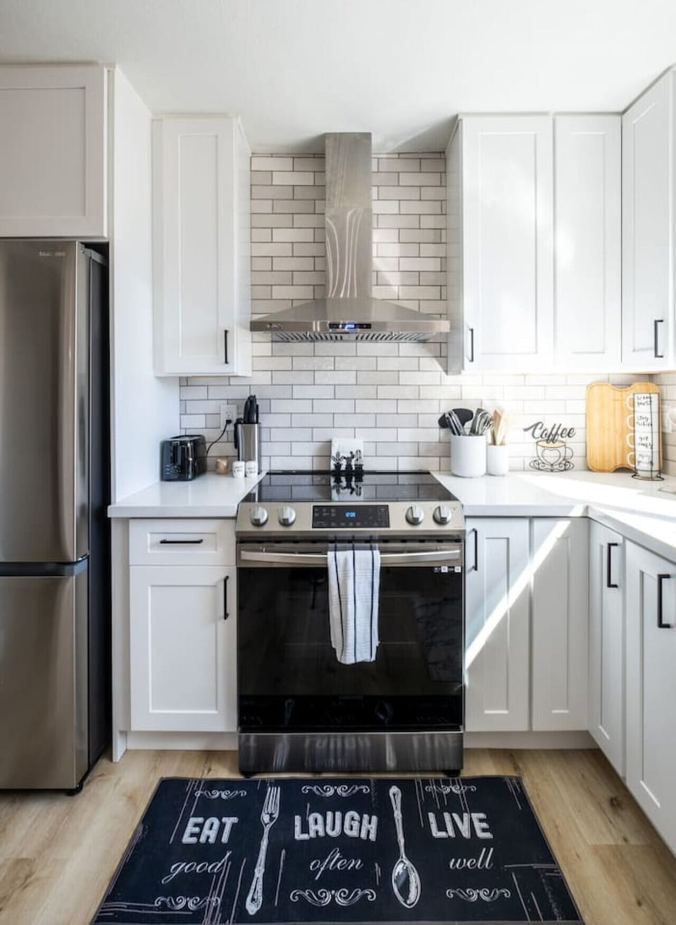 Kitchen with a beautiful industrial hood and spice rack. All new appliances like toaster and coffee machine.