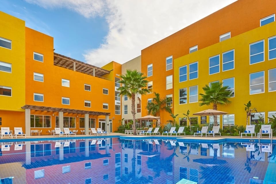 Dive into a vibrant courtyard pool with sunny reflections.