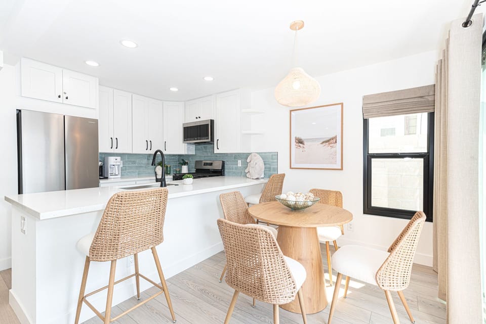 Gather in the airy, open-concept dining area featuring sleek finishes and bar seating, perfect for casual meals
                