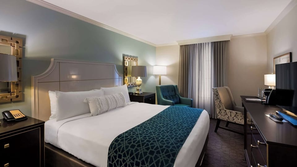 Settle into a serene room with plush bed and warm lighting.