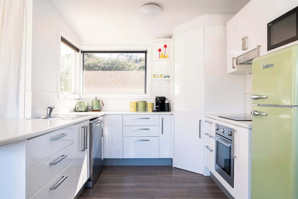 The light-filled kitchen with a coffee machine and dishwasher.