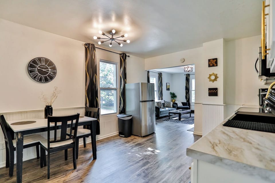 A modern kitchen equipped with high-end appliances and ample lighting. It has a coffee maker, oven, stove top, utensils, and all it takes to fix a delicious meal.