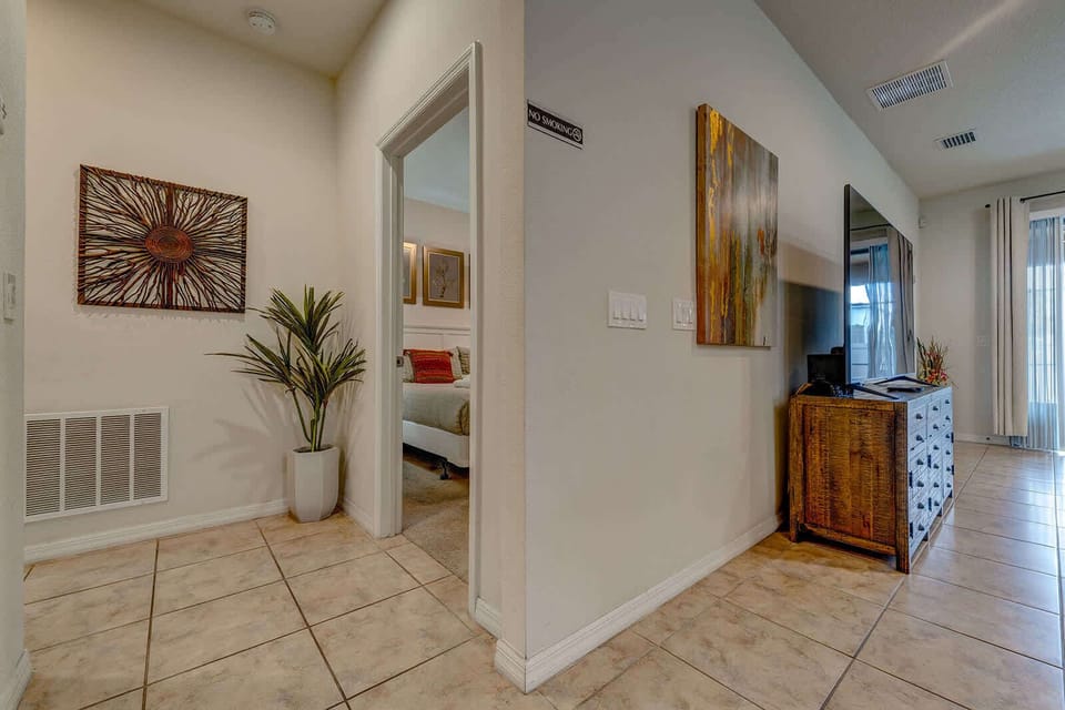 Entryway with tile flooring leading to a bedroom and living area with natural light.