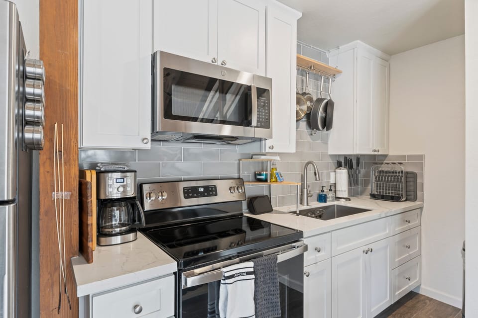 Another look at the kitchen, with countertop shelves, range, microwave, and refrigerator.