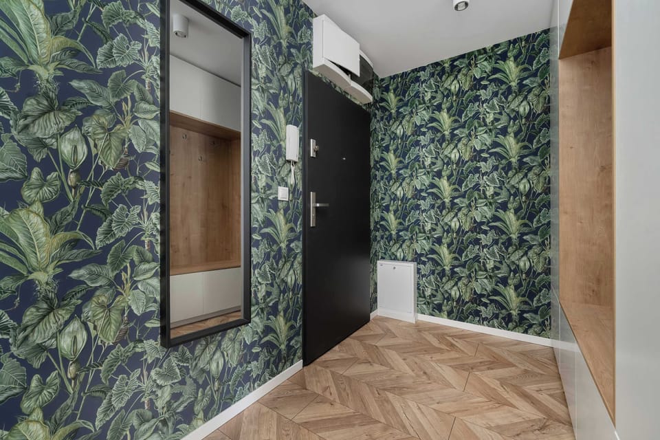 Hallway with leafy wallpaper, adding a bold and modern accent.