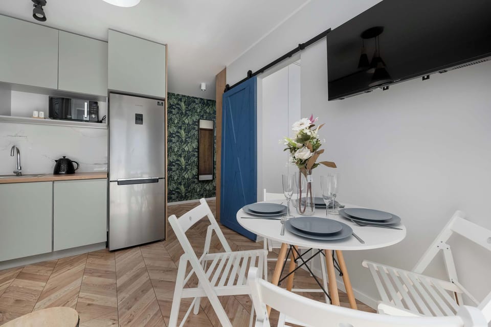 Compact modern kitchen with wooden countertop, white cabinets and built-in appliances.