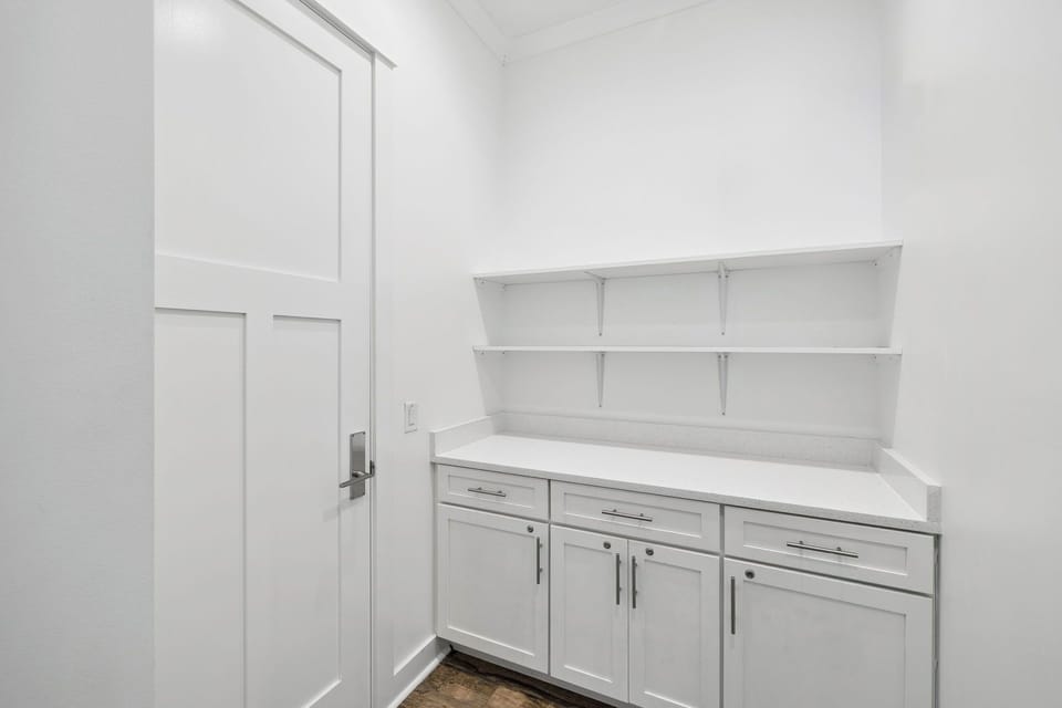 Your private pantry offers abundant storage with sleek white cabinetry and open shelving for easy organization.