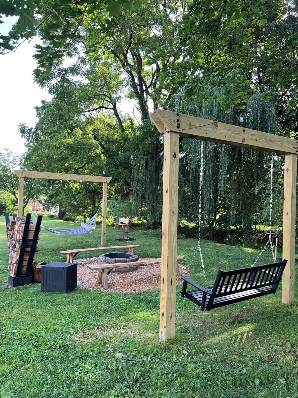 Firepit with seating, hammock, and swing for relaxing evenings outdoors.