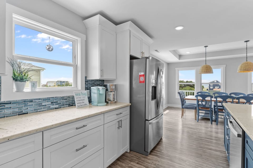 Top Level Main Kitchen Area w/ Stainless Steel Refrigerator, Oven & Range, Microwave, Dishwasher,  Spacious Island w/ Modern Finishes, and Breakfast Bar