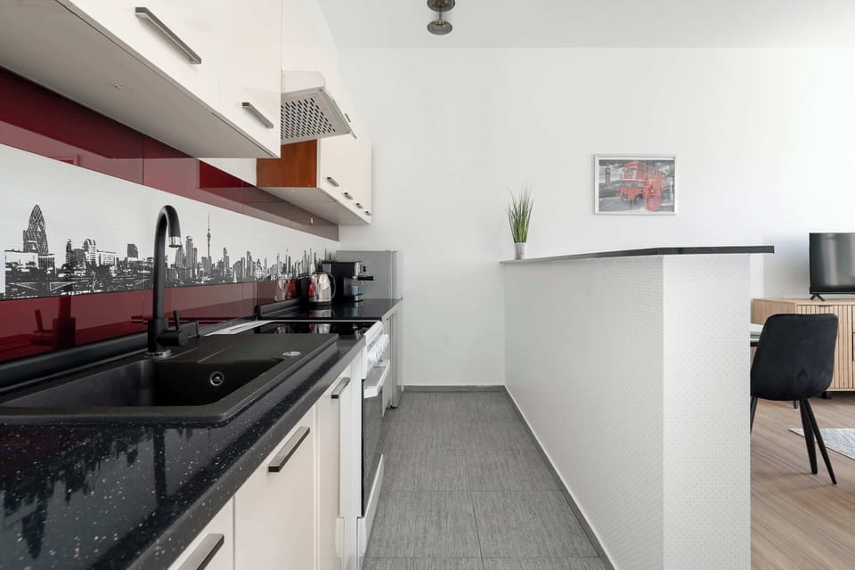 A functional kitchen with a gas stove, oven, and ample counter space. The red accents add a touch of modern style.