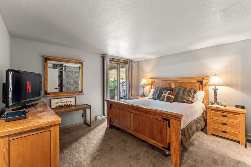 【Second Bedroom — Twin Room】Two twins with red plaid bedding and a dresser + TV