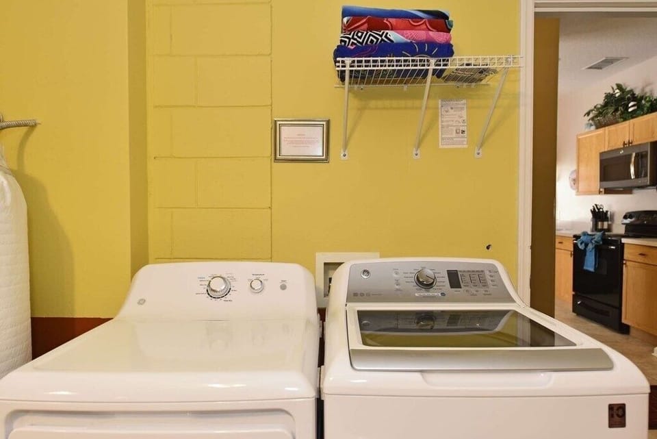 In-home laundry room with washer, dryer, and storage shelves.