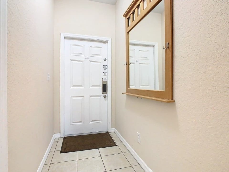 right entryway with a large mirror and natural lighting leading to the living spaces.