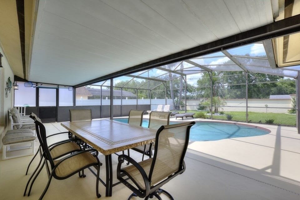 BPT_6850And4moreCovered patio with dining space overlooking the pool, ideal for outdoor meals or lounging.