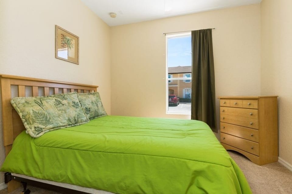 Bright and cheerful bedroom with a vibrant green bedspread.