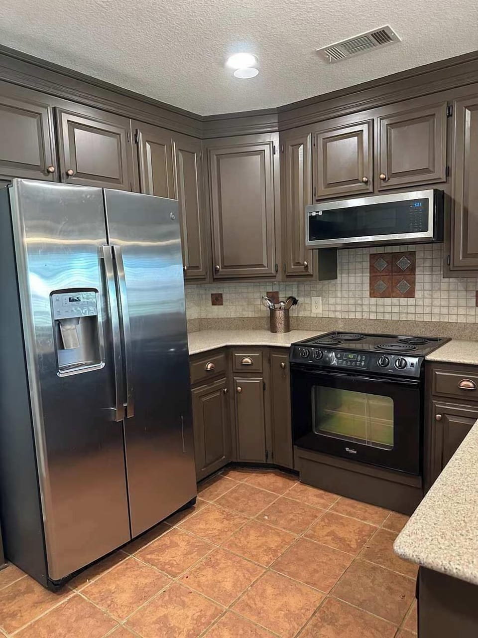 Microwave/vent hood above stove. Water and ice external dispenser in stainless steel refrigerator