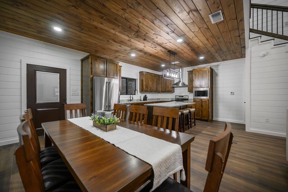 Rustic kitchen and dining space with wood ceiling and farmhouse charm. 