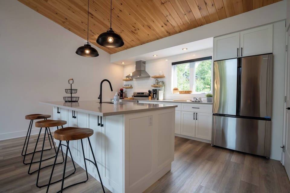 Cuisine très bien équipée, îlot au centre, grand garde-manger, 3 tabourets, vue sur la pièce / Very well equipped kitchen, island in the center, large pantry, 3 stools, view of the room (3)