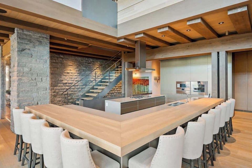 - Spacious kitchen with sleek countertops and wooden ceiling beams  
- Large breakfast bar with plush seating for social gatherings  
- Modern appliances and open layout ideal for group cooking  
