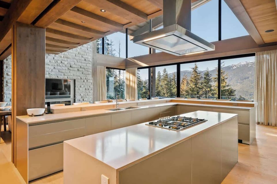 - Modern kitchen with mountain views through tall glass windows  
- Sleek island design with premium appliances and open layout  
- Cook with a view in this bright alpine-inspired space  
