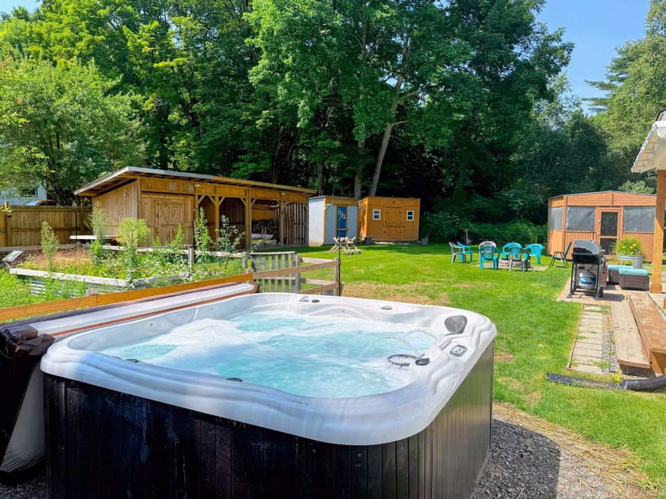 The back yard offers a private area to relax with a hot tub, fire pit, grill, and seating.