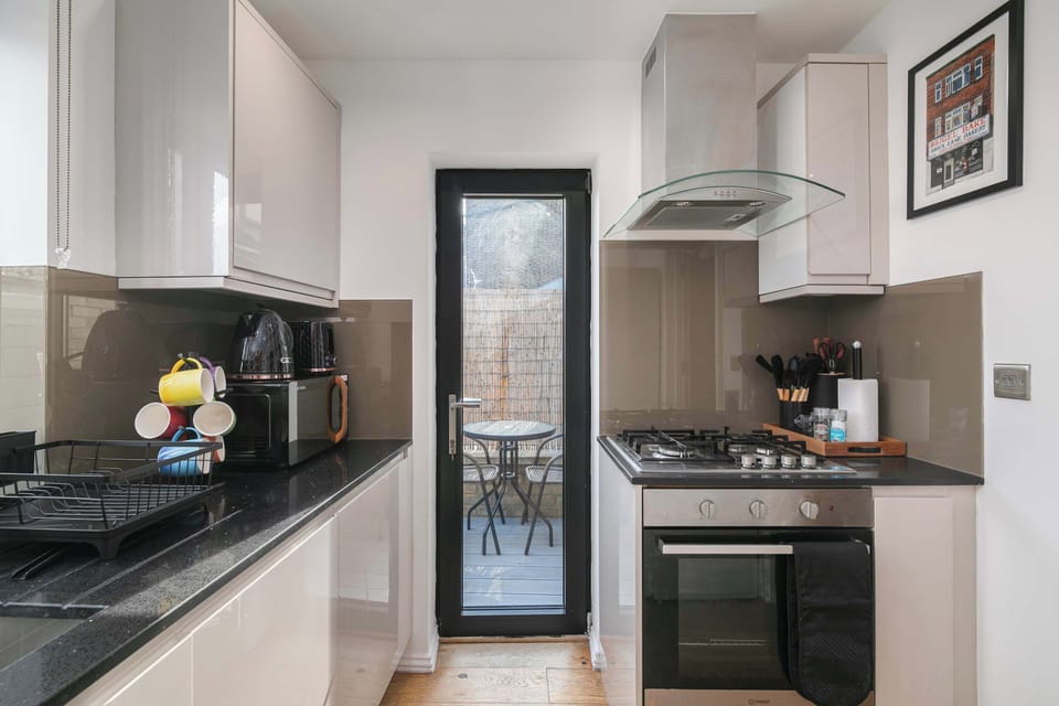 Stylish modern kitchen featuring oven, hob and a dedicated coffee bar, fully equipped for comfortable stays with complimentary coffee and tea.