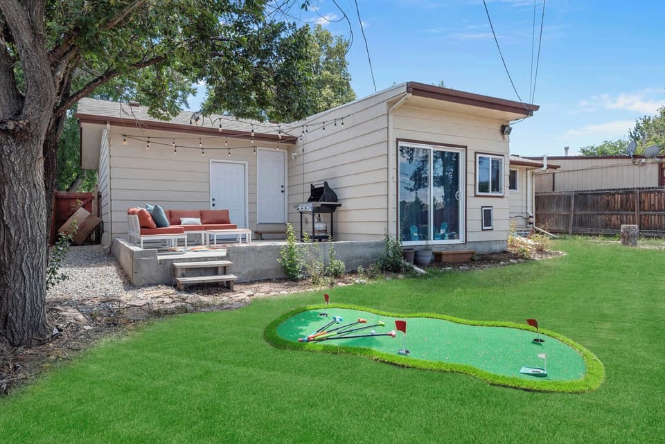 Backyard featuring mini golf, patio seating, and a relaxing outdoor hangout space.