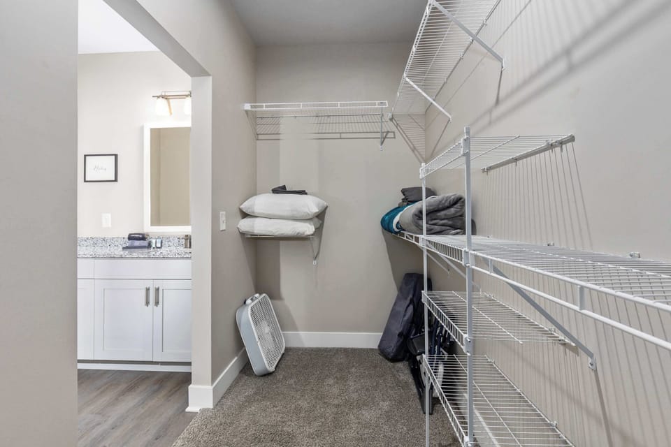 Master walk-in closet with plenty of storage and extra bedding for the sofa bed.