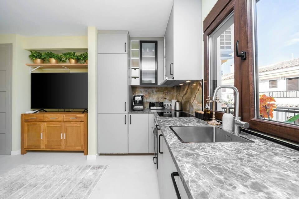 Fully equipped kitchen with natural light, including a coffee machine together with necessary coffee beans.