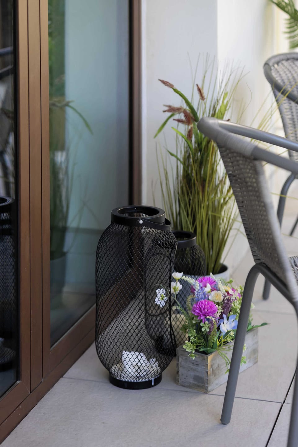 Detailed view of a balcony corner with decorative lanterns, ceramic pots, and green plants, enhancing the relaxing outdoor vibe.