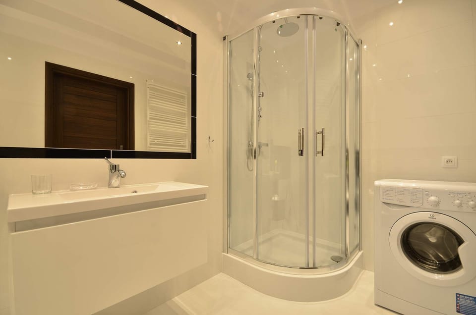 Functional bright bathroom with washing machine.