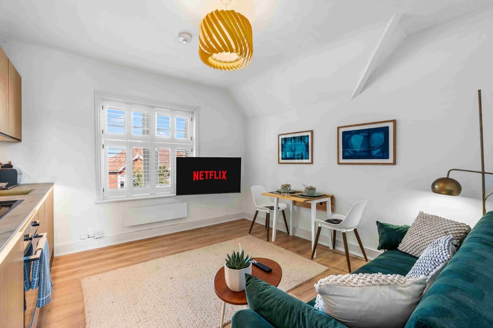 Bright and airy living room with large windows, stylish decor, and a comfortable sofa perfect for relaxing.
