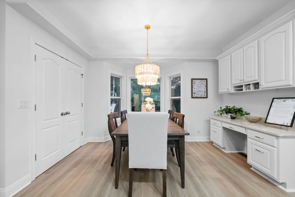 Bright dining space with wooden table and elegant chandelier.