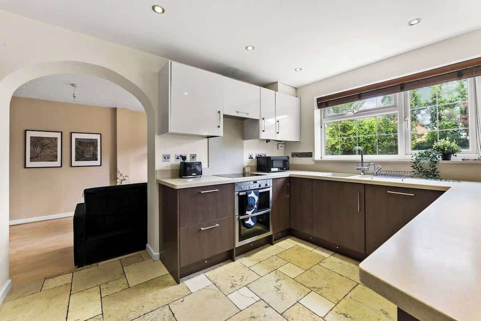The contemporary kitchen boasts a functional U-shaped layout with sleek cabinetry and high-quality stone flooring.