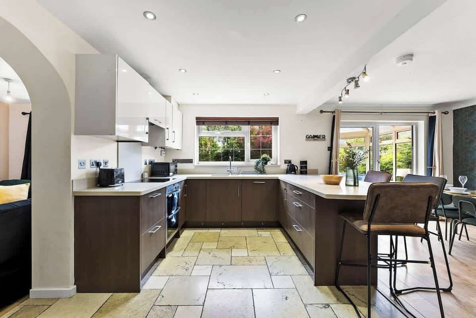 A wide-angle view reveals the spaciousness of the kitchen, featuring a breakfast bar and integrated appliances.