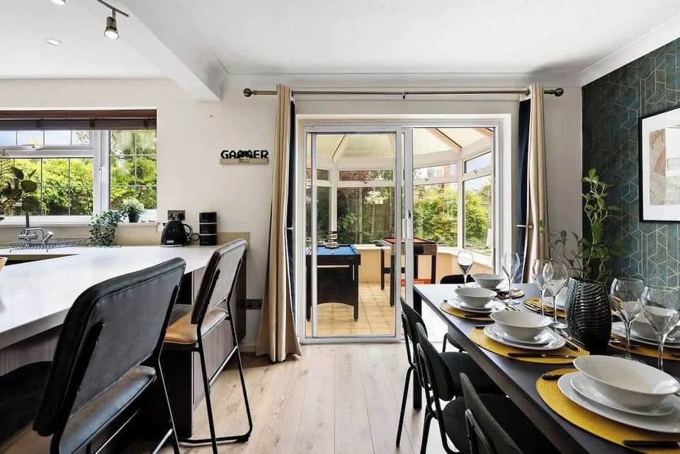 This view emphasizes the open-plan flow from the dining room into the bright conservatory and modern kitchen.