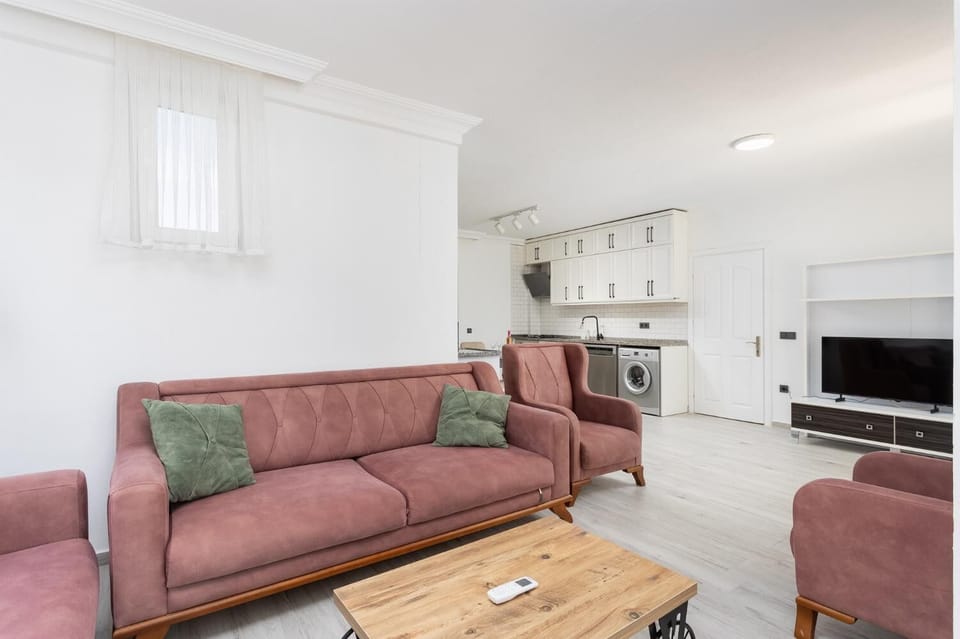 Open-plan living room with sofas, dining area, kitchen, A/C, WiFi internet, and satellite TV